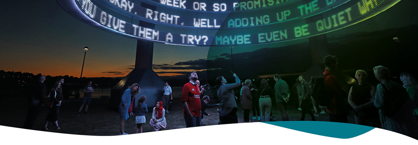 People outside looking at artwork